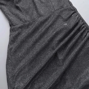 Close-up of ruched dark grey dress with shimmering metallic glitter fabric detail