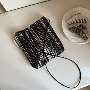 Detail of tweed crossbody phone bag with black leather strap and Simple wish label