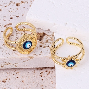 Adjustable golden evil eye sunburst ring featuring blue enamel and double-row band