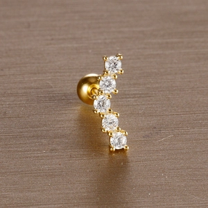 Detailed macro view of curved gold leaf stud earring with white cubic zirconia crystals