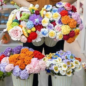 Detailed view of colorful handmade crochet flower bouquets featuring roses and lilies