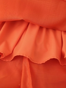 Détail du tissu en mousseline orange corail montrant les coutures et la double épaisseur
