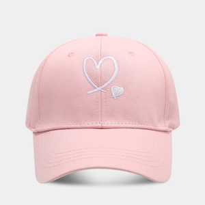 Detailed close-up of pink baseball cap featuring white heart embroidery and stitching