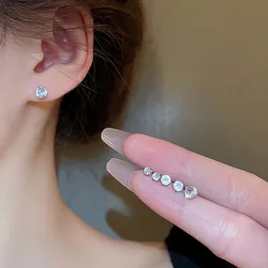 Silver needle round zircon stud earrings set in five different sizes shown on hand