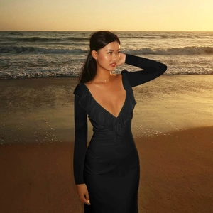 Detail of ruffled deep V-neckline and slim-fit long sleeves on a black stretch knit dress