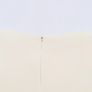 Detail of beige bubble sleeve top showing fabric texture and invisible back zipper closure