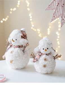 Detail of plush Christmas snowmen set with pink knit hats and wood buttons décor