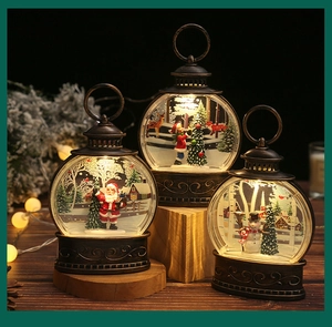 Detailed view of bronze Christmas lanterns with Santa and Snowman inside with swirling snow