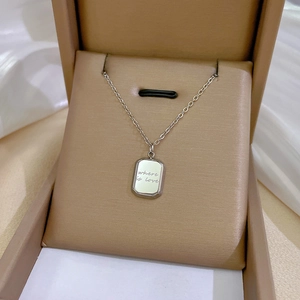 Macro detail of silver titanium steel square pendant engraved with Where is Love
