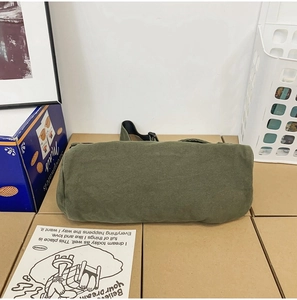 Close-up of green washed canvas bag texture and relaxed style messenger bag