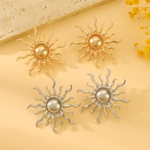 Macro shot of sunburst earrings with center pearls in gold and silver finish