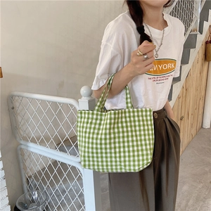 Green and white plaid cotton linen tote bag being carried by a model on stairs