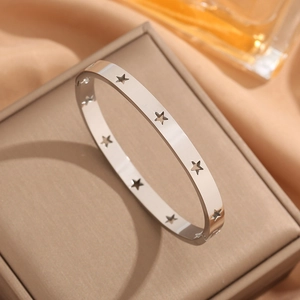 Polished silver 18k stainless steel bangle with hollow star pattern on jewelry box