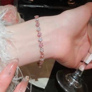 Close-up of rose gold flower bracelet with pink and white zircon stones on a wrist