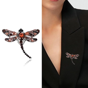Creative dragonfly brooch with brownish crystals shown on white background and model