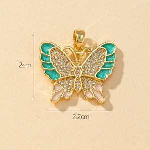 Macro shot of 2cm by 2.2cm gold butterfly pendant with turquoise enamel and crystals