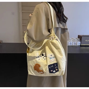 Detailed side view of the large capacity canvas tote bag with cartoon puppy embroidery