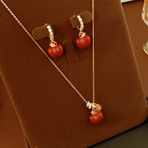 Dettaglio del set collana e orecchini a mela placcati in oro 18k con pietre e zirconi