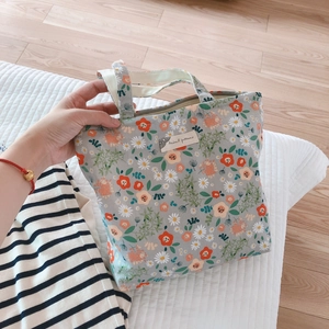 Close-up of floral cotton tote bag with animal pattern label and sturdy dual handles