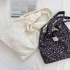 Detail of floral puff tote bag featuring 3D seersucker texture and brand label