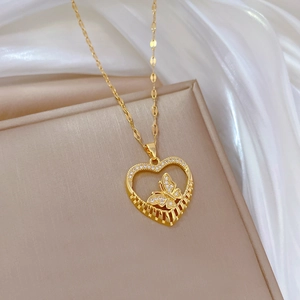 Elegant gold butterfly heart necklace with crystals on beige display stand