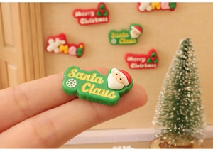 Close-up of a miniature Santa Claus dollhouse ornament with festive gold engraving