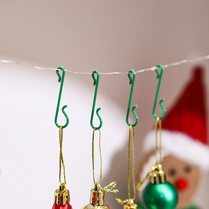 Green S-shaped metal hooks for hanging Christmas tree ball ornaments and festive decorations