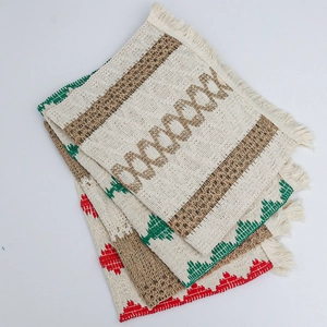 Detailed view of woven cotton linen placemats with geometric patterns and fringe edges