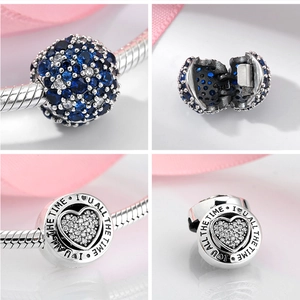 Detailed macro of S925 sterling silver charms with blue stones and heart engraving