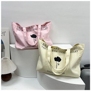 Detail of canvas tote bags with floral prints in pink and cream on a decorative stand
