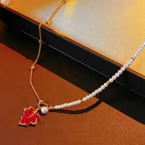 18K gold plated necklace with pearls and red maple leaf pendant on a luxury jewelry box