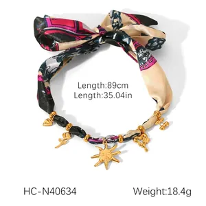 Detail view of printed silk scarf necklace with golden heart and sun charms dimensions