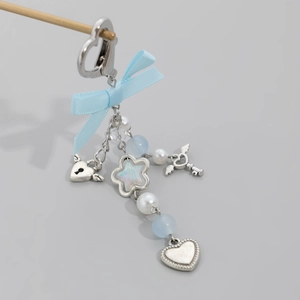 Close-up of heart-shaped keychain with blue ribbon bow and iridescent star charms