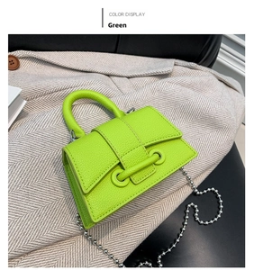 Detail of neon green mini beaded handle bag with pebble leather texture and silver chain
