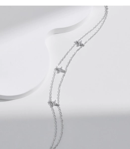 Macro shot of double-layer silver star bracelet with micro-paved zircons on white props