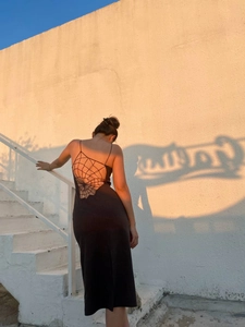 Detail of backless black dress featuring intricate spider web cutout design on back