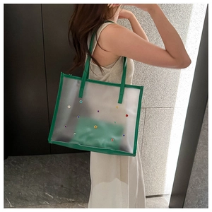 Transparent PVC tote bag with colorful rhinestones and green trim shown on a model