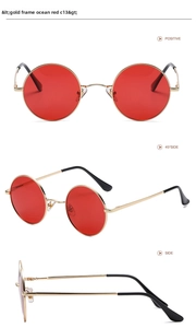 Detailed view of vintage round sunglasses with gold metal frames and ocean red lenses