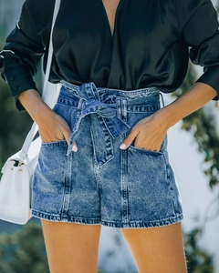 Dettaglio degli shorts in denim blu retrò a vita alta con cintura abbinata e tasche