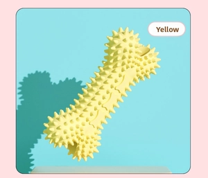 Dettaglio macro del giocattolo per cani giallo a forma di osso con punte per i denti
