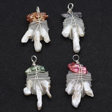 Détail de quatre pendentifs artisanaux avec perles baroques et pierres de quartz naturel