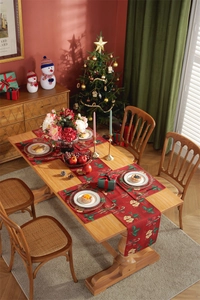 Close-up of festive red Christmas table runner and mat set with holly and bells pattern
