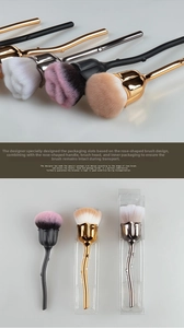 Detail of rose-shaped makeup brush with soft bristles and metallic thorn stem handle