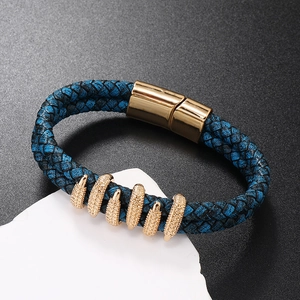 Blue braided leather bracelet with golden magnetic clasp on a white stone base