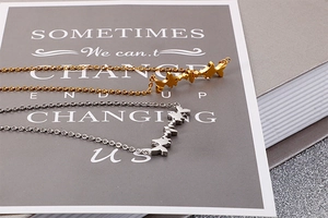 Close-up of gold and silver heartbeat necklaces with wave pendant on O-chain link