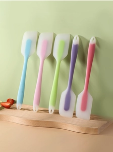 Set of five colorful silicone spatulas on a wooden board for baking and mixing