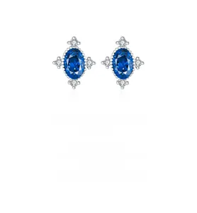 Macro detail of S925 silver oval blue sapphire earrings with starburst accent diamonds