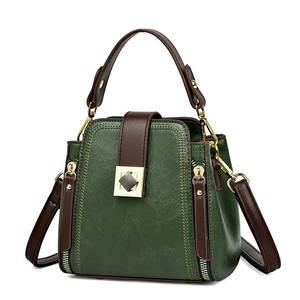 Retro dark green bucket bag with brown handles and golden twist lock on white background