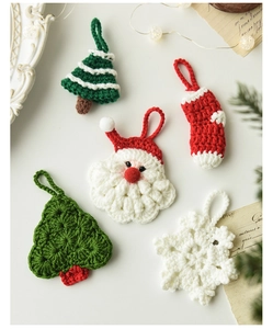 Dettaglio di ornamenti natalizi fatti a mano all'uncinetto con Babbo Natale e albero