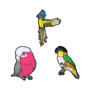 Three colorful cartoon parrot metal badges on white background for clothing decoration